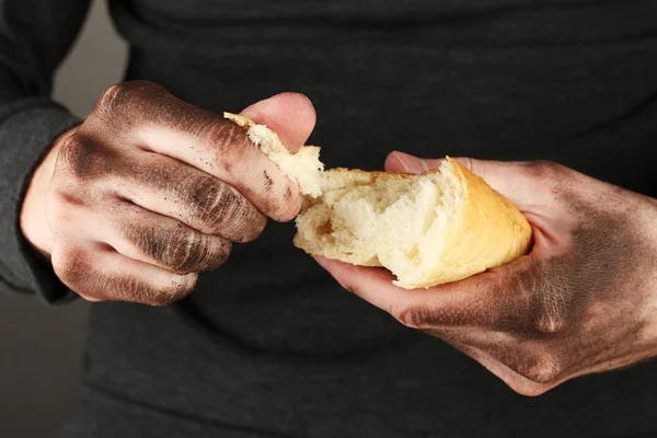 Sem-teto homem segurando um pão branco, close-up — Fotografia de Stock