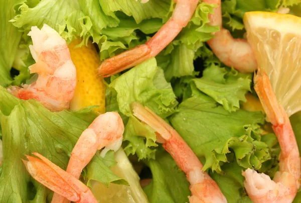 Salad with shrimps, lemon and lettuce leaves in bowl, close up — Stock Photo, Image