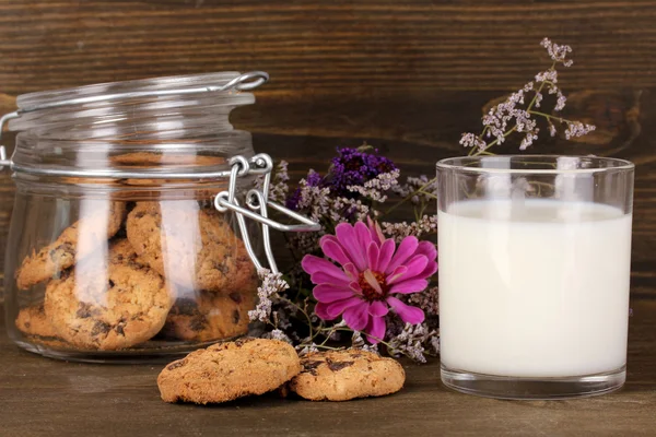 Glass of milk with cookies on wooden table close-up — Stock Photo, Image