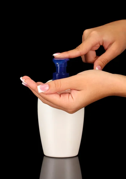 Kvinna klämma lotion på hennes hand, på svart bakgrund närbild — Stockfoto