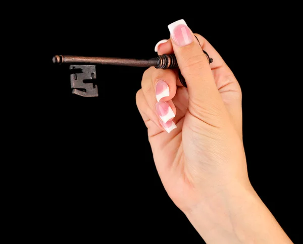 Frauenhand mit Schlüssel, auf schwarzem Hintergrund Nahaufnahme — Stockfoto