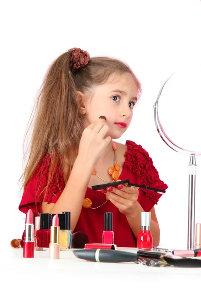 Little girl in her mother's dress, is trying painting her face Stock Picture