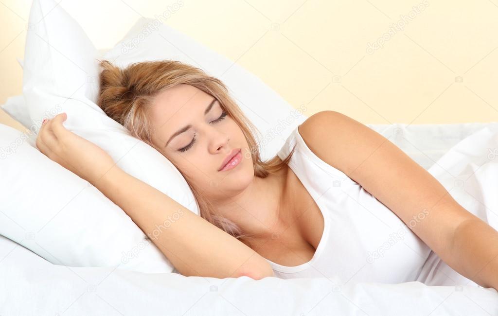 young beautiful woman sleeping on bed in bedroom