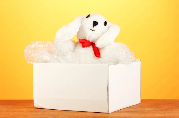 Opened parcel with a child's toy on yellow background close-up — Stock Photo, Image