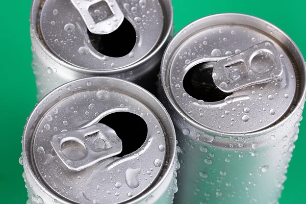 Aluminium blikjes met water druppels op groene achtergrond — Stockfoto