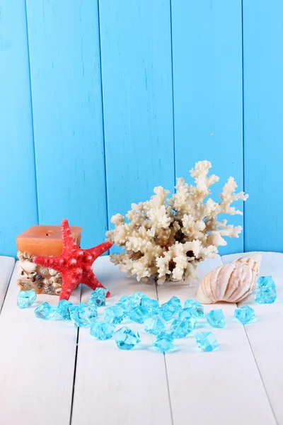 Inrichting van schelpen op houten tafel op blauwe houten achtergrond — Stockfoto