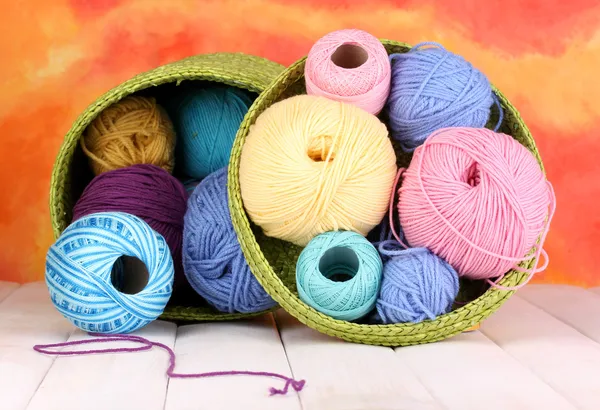 Filato colorato per lavorare a maglia in cesto verde su tavolo di legno bianco su colorfu — Foto Stock