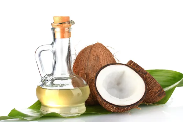 Decantador com óleo de coco e coco isolado sobre branco — Fotografia de Stock