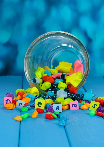 Pezzi di carta sparsi e pietre colorate con sogni in vaso di vetro su b — Foto Stock