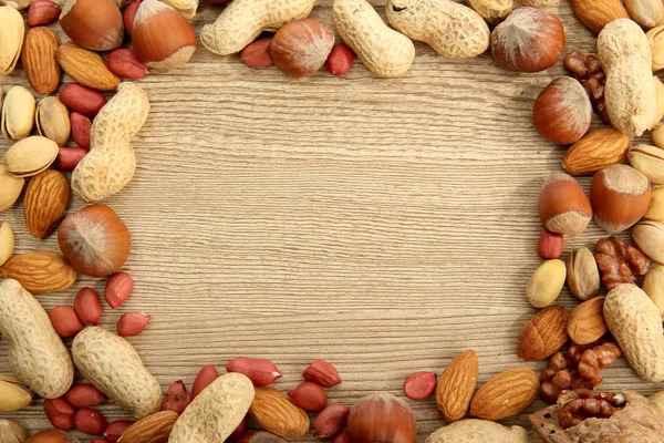 木製の背景においしいナッツの盛り合わせ — ストック写真