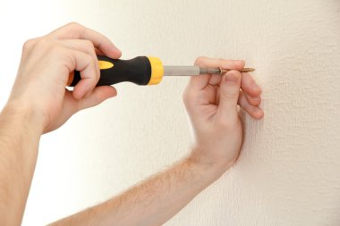 adamın elinde tornavida ve vida ile