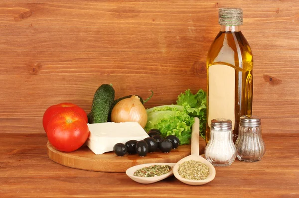 Ingredients for a Greek salad on wooden background close-up — Stock Photo, Image