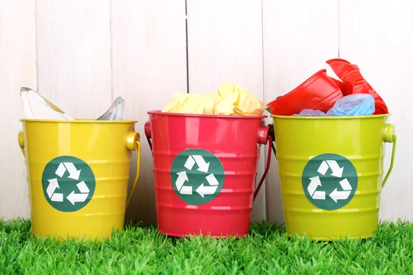 Recycling bakken op groen gras in de buurt van houten hek — Stockfoto