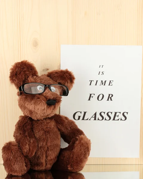 Gezichtsvermogen test-chart met glazen en speelgoed op houten achtergrond close-up — Stockfoto