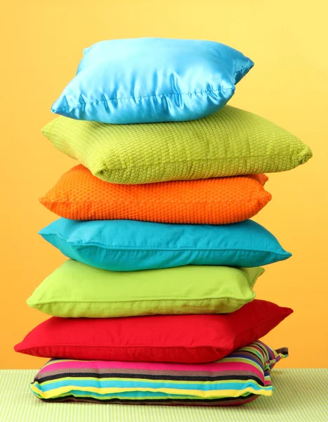 Travesseiros coloridos no fundo amarelo — Fotografia de Stock