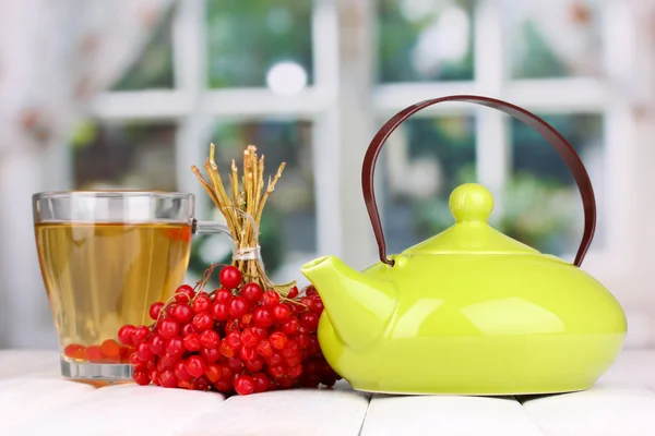 Chá com viburnum vermelho na mesa no fundo brilhante — Fotografia de Stock