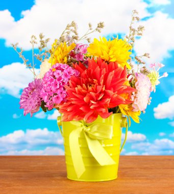 gökyüzü arka plan üzerine çiçekli parlak yeşil kova