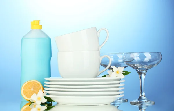 Empty clean plates, glasses and cups with dishwashing liquid and lemon on b — Stock Photo, Image