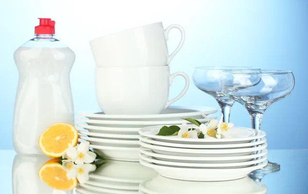 Empty clean plates, glasses and cups with dishwashing liquid and lemon on b — Stock Photo, Image