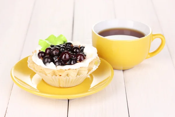 Zoete cake met kopje thee op houten achtergrond — Stockfoto