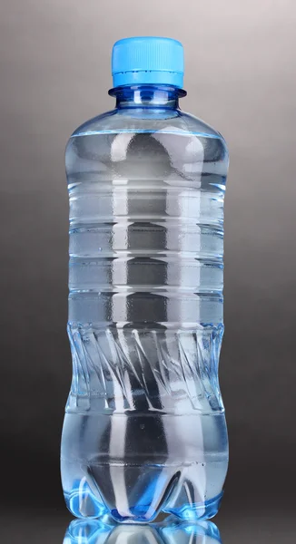 Plastikflasche mit Wasser auf grauem Hintergrund — Stockfoto
