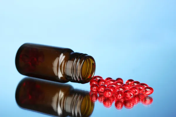 Jar de pílulas no fundo azul close-up — Fotografia de Stock