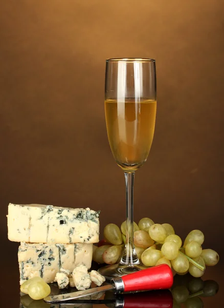 Formaggio con muffa e calice di vino su sfondo marrone primo piano — Foto Stock