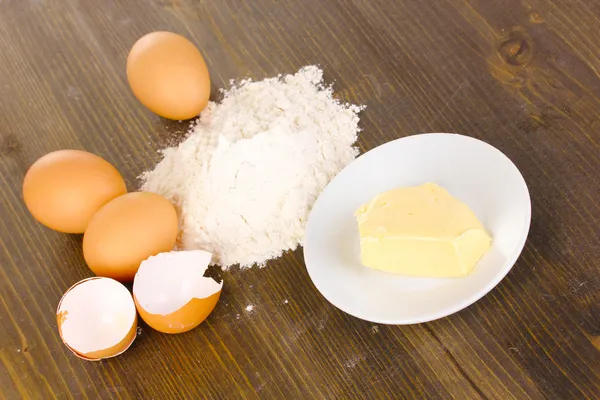 Αυγά, αλεύρι και βούτυρο κοντινό πλάνο για στη ξύλινο τραπέζι — Φωτογραφία Αρχείου