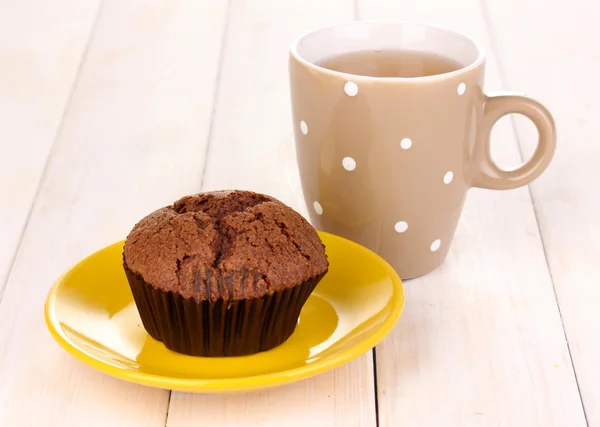 Frischer Muffin mit Tee auf Holzgrund — Stockfoto