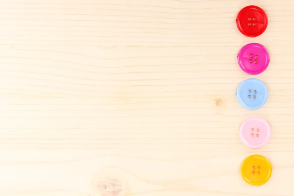 Colorful sewing buttons on wooden background — Stock Photo, Image