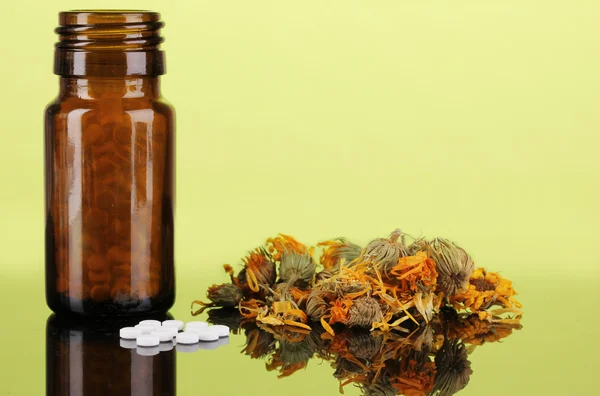Fles met pillen en kruiden op groene achtergrond. concept van de homeopathie — Stockfoto