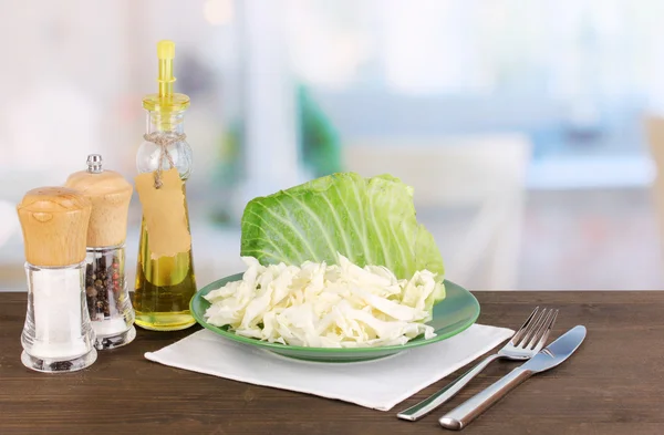 Plate with coleslaw and seasonings on wooden table on room background — Stock Photo, Image