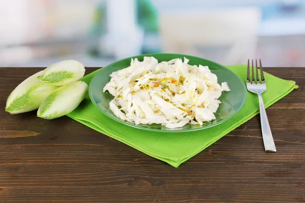 Plate with coleslaw and chicory on wooden table on room background — Stock Photo, Image