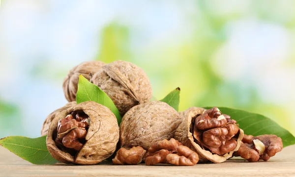 Nueces con hojas verdes, sobre fondo verde — Foto de Stock