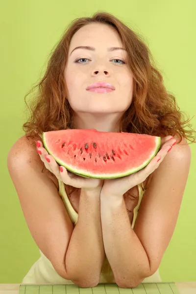 Usmívající se krásná dívka s meloun na zeleném pozadí — Stock fotografie
