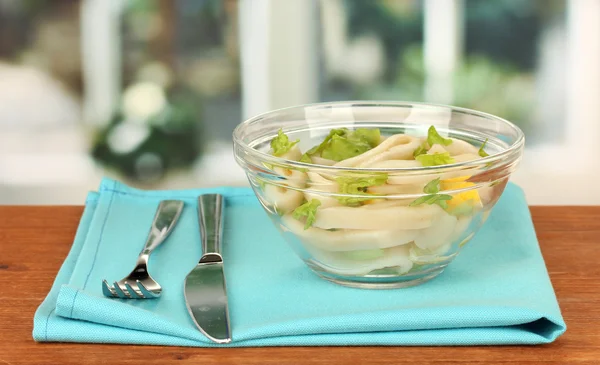 Salade de calmars, citron et laitue dans un bol en verre sur table en bois clo — Photo