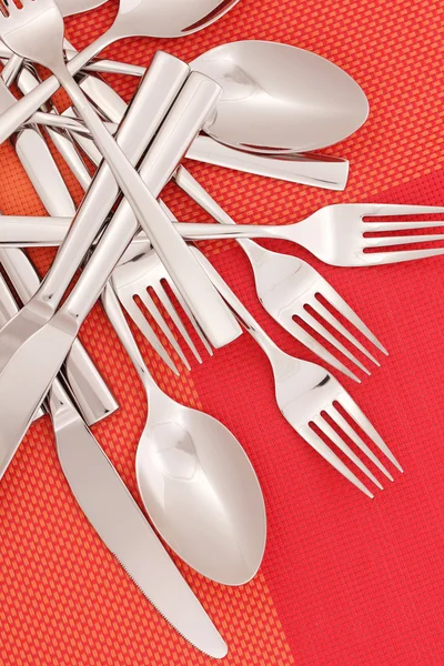 Forks, knifes and spoons on red mat close-up — Stock Photo, Image