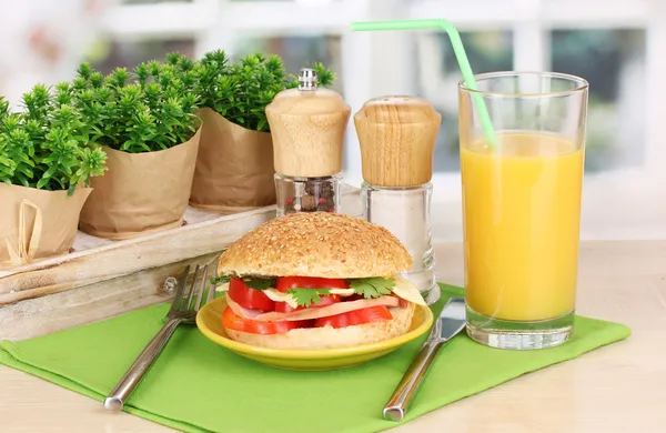 Sandwich apetitoso en la placa de color en la mesa de madera en el fondo de la ventana — Foto de Stock