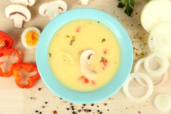 Duftende Suppe in blauer Schüssel mit Zutaten auf dem Tisch in Großaufnahme — Stockfoto