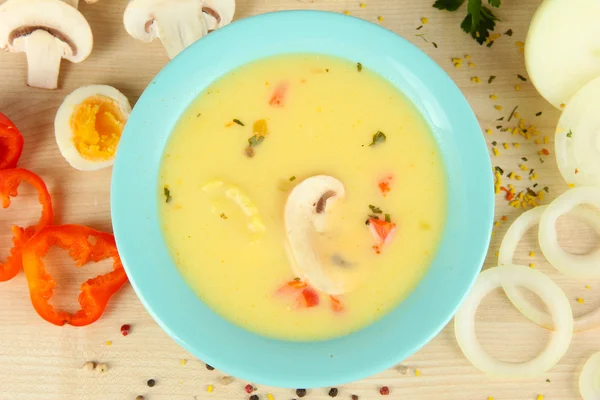 Sopa fragante en tazón azul con ingredientes alrededor en la mesa de cerca — Foto de Stock