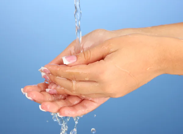 青色の背景のクローズ アップで女性の手を洗う — ストック写真