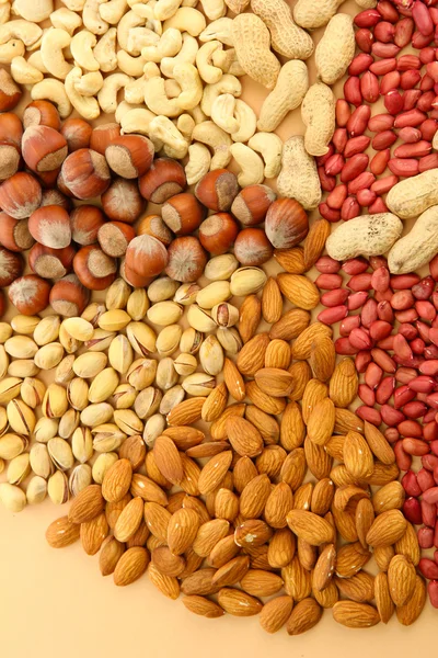 Sortiment av välsmakande nötter, på beige bakgrund — Stockfoto