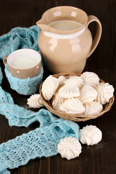 Jarra y taza de leche con merengues en mesa de madera de cerca — Foto de Stock