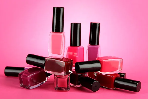 Group of bright nail polishes, on pink background — Stock Photo, Image