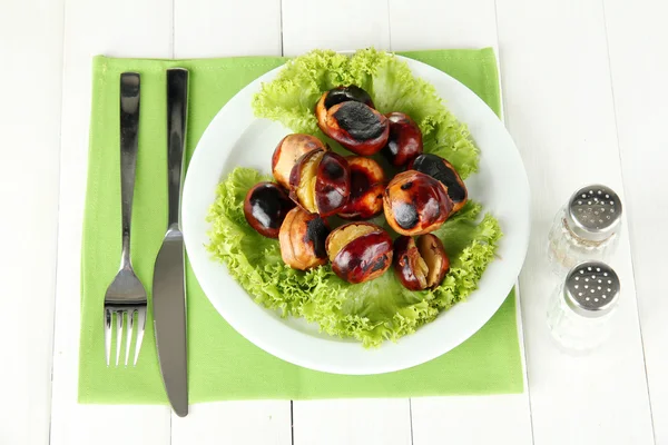 Rostade kastanjer med sallad i plattan på vit trä bakgrund — Stockfoto