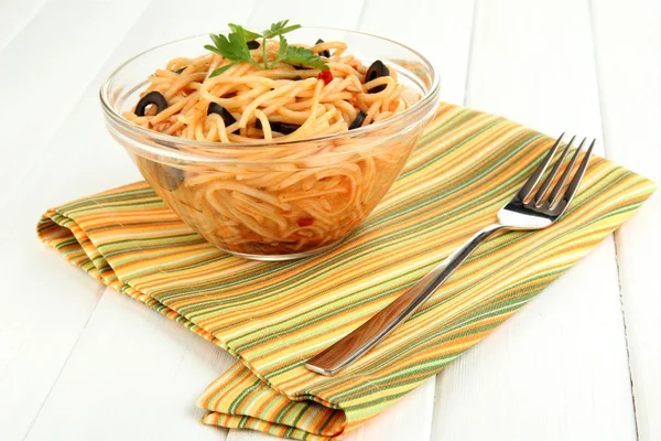 Włoskie spaghetti w szklanej misce na drewnianym stole — Zdjęcie stockowe