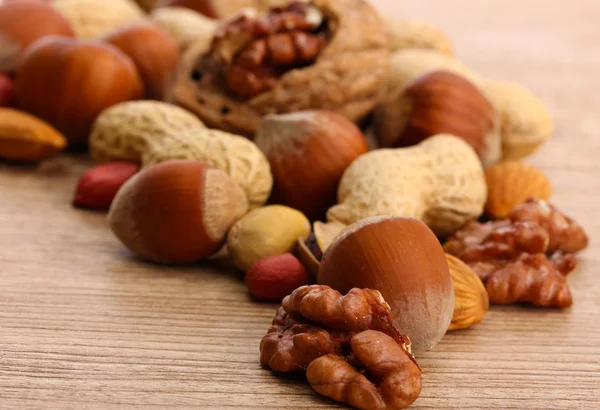 Assortment of tasty nuts on wooden background — Stock Photo, Image