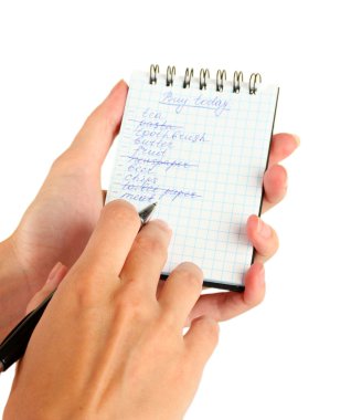 Kadının elinde alışveriş listesi olan bir defter var.