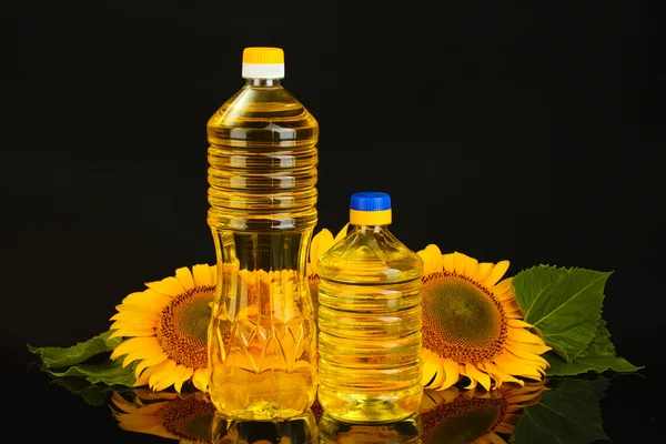 Sunflower oil and sunflower isolated on black — Stock Photo, Image