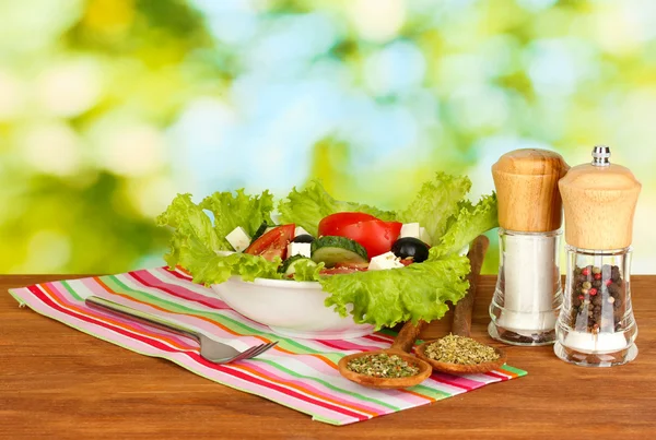 Tasty greek salad on bright green background — Stock Photo, Image